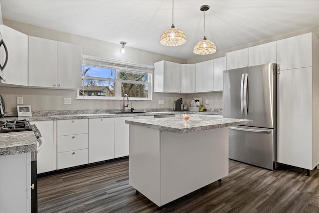 kitchen with a center island, white cabinetry, stainless steel refrigerator, and sink