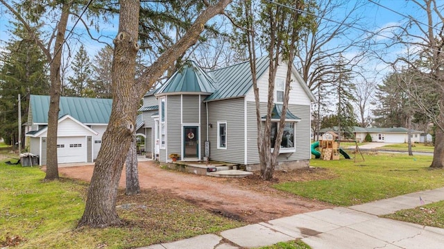 view of front of property featuring a playground, a front lawn, cooling unit, a garage, and an outbuilding