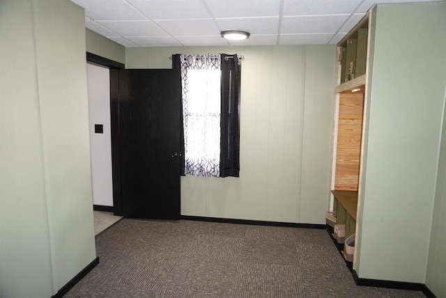 carpeted spare room with a drop ceiling