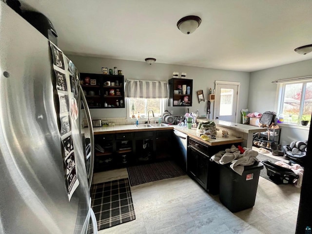 kitchen featuring kitchen peninsula, a wealth of natural light, sink, and appliances with stainless steel finishes