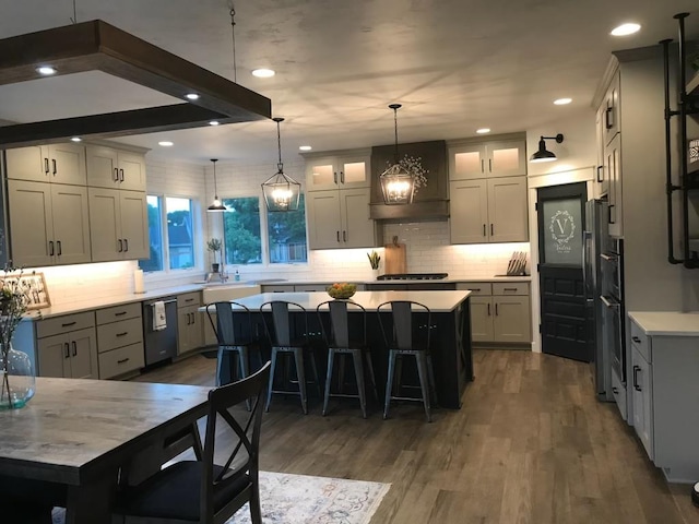 kitchen featuring a breakfast bar, custom range hood, stainless steel appliances, dark wood-type flooring, and a center island