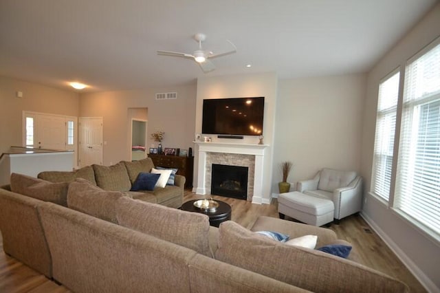 living room with ceiling fan and light hardwood / wood-style flooring