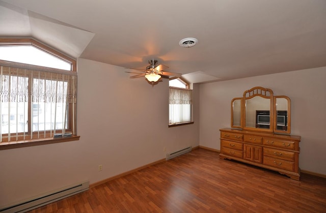 unfurnished bedroom featuring wood-type flooring, lofted ceiling, ceiling fan, and a baseboard heating unit