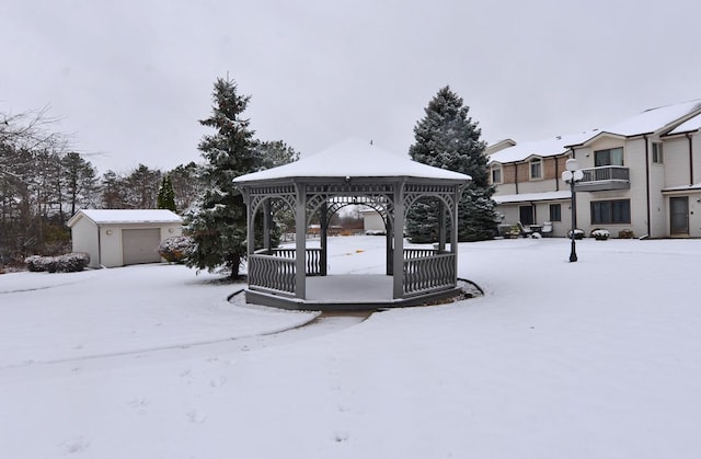 snowy yard with a gazebo and an outdoor structure