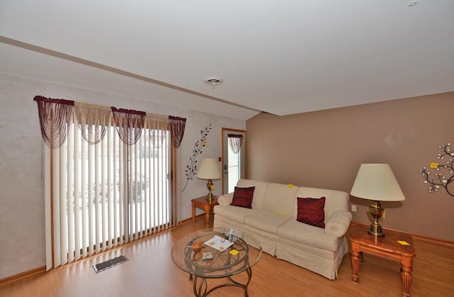 living room with vaulted ceiling and hardwood / wood-style flooring