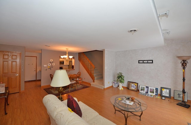 living room featuring wood-type flooring and an inviting chandelier