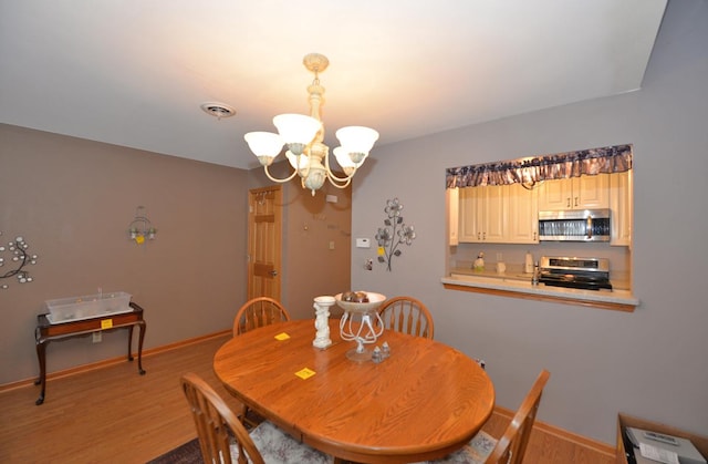 dining area with a chandelier and light wood-type flooring