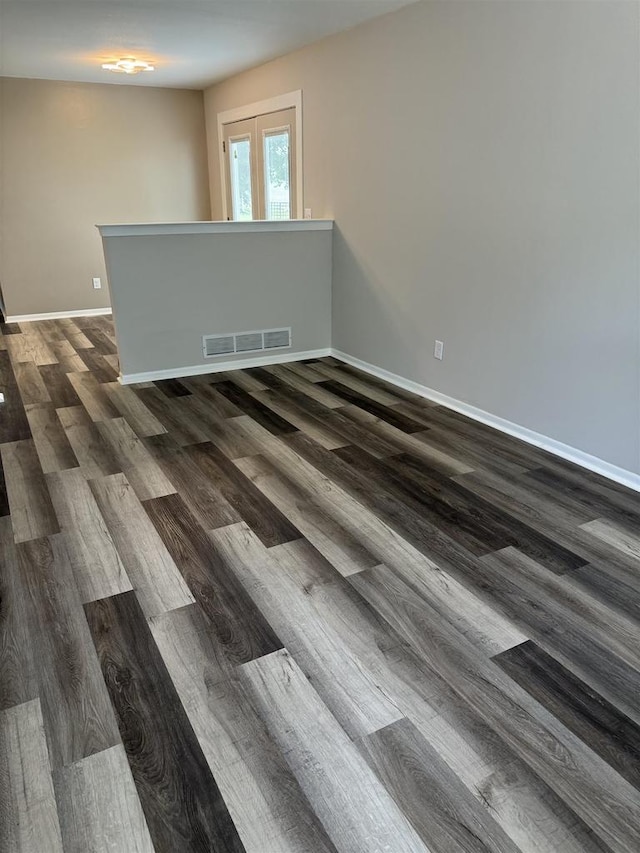 unfurnished room with french doors and dark wood-type flooring