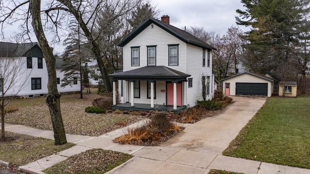 view of front facade with a porch, a garage, a front lawn, and an outdoor structure