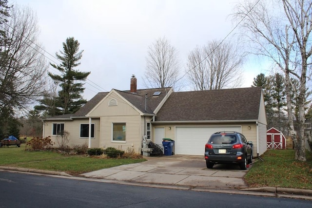 single story home with a front lawn, a storage unit, and a garage