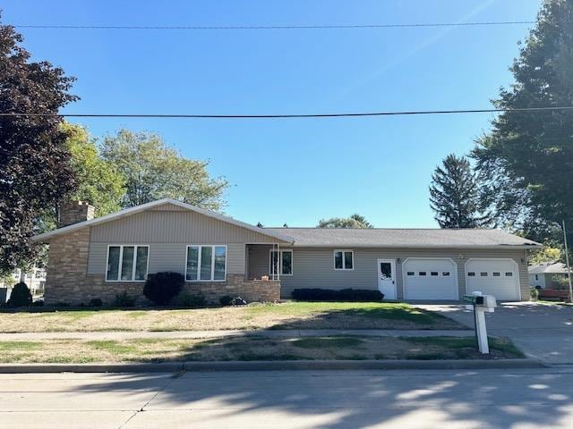 single story home featuring a garage and a front lawn