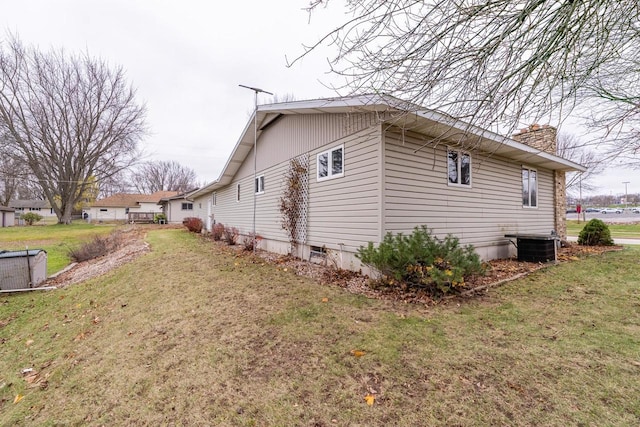 view of property exterior with a yard and central AC unit