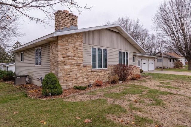 view of home's exterior featuring central AC, a yard, and a garage