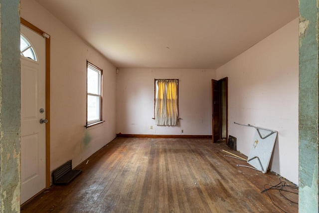 unfurnished room with dark hardwood / wood-style floors and plenty of natural light