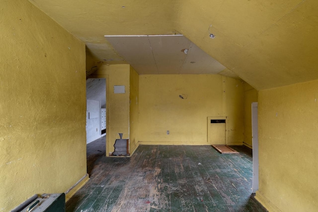 additional living space with dark wood-type flooring and lofted ceiling