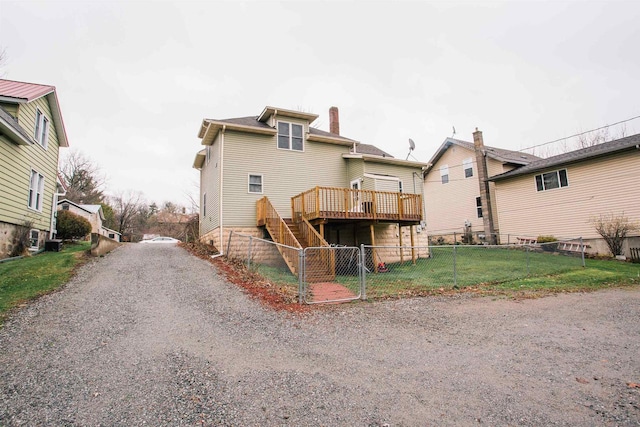 rear view of property with central air condition unit, a deck, and a lawn