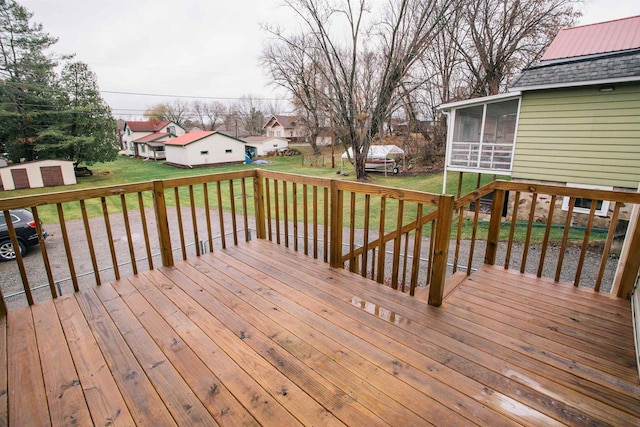 wooden terrace featuring a lawn and a sunroom