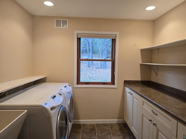 laundry room featuring cabinets, independent washer and dryer, dark tile patterned floors, and sink