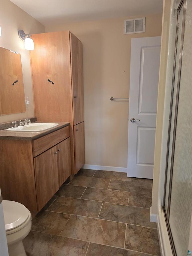 bathroom featuring vanity, toilet, and walk in shower