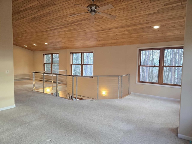 spare room featuring carpet flooring, vaulted ceiling, ceiling fan, and wood ceiling