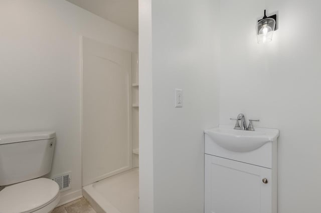 bathroom featuring tile patterned floors, walk in shower, vanity, and toilet