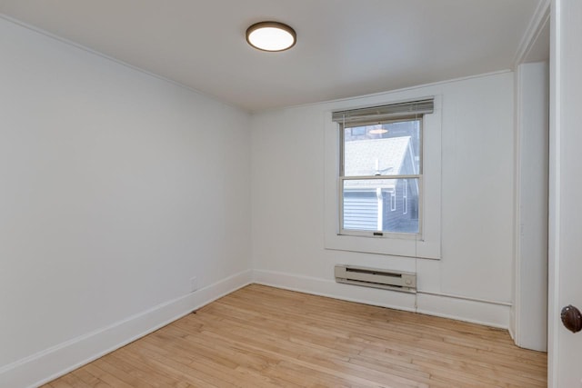 empty room with light hardwood / wood-style flooring and baseboard heating