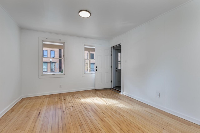 unfurnished room with light hardwood / wood-style flooring and crown molding