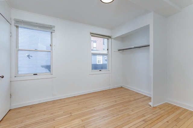 unfurnished bedroom with light hardwood / wood-style floors and a closet