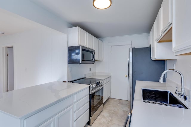 kitchen featuring white cabinetry, sink, light stone countertops, and appliances with stainless steel finishes