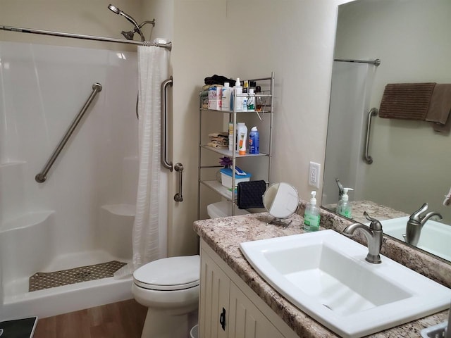 bathroom featuring a shower with shower curtain, hardwood / wood-style floors, vanity, and toilet