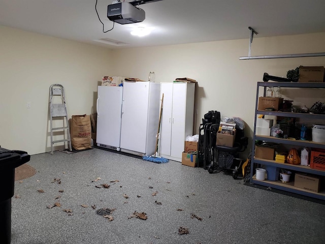 garage with white fridge and a garage door opener