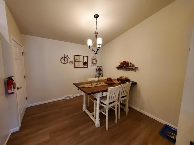 dining room featuring dark hardwood / wood-style floors and a chandelier