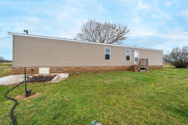 back of house with a yard and a patio