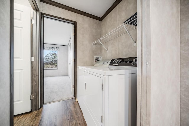 laundry area with crown molding, washer and clothes dryer, and dark wood-type flooring