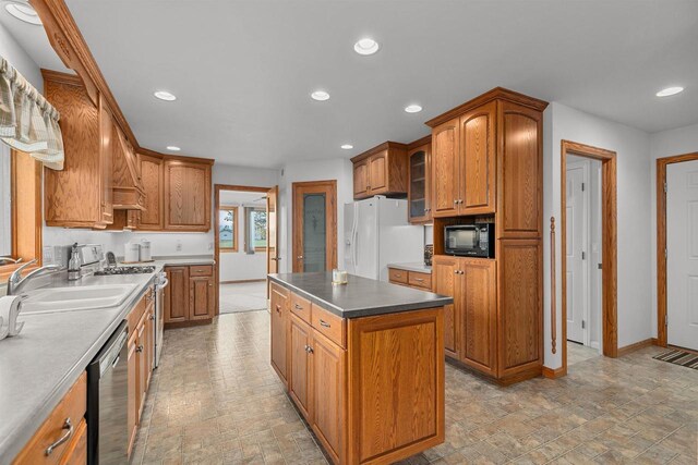 4207 Lost Dauphin Rd, De Pere, WI 54115 - kitchen with appliances with stainless steel finishes, recessed lighting, brown cabinetry, a center island, and stone finish flooring