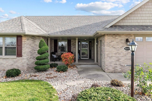 4207 Lost Dauphin Rd, De Pere, WI 54115 - view of exterior entry with covered porch, brick siding, and roof with shingles