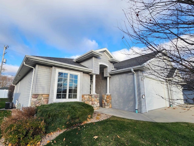 ranch-style home featuring concrete driveway, stone siding, cooling unit, and a garage