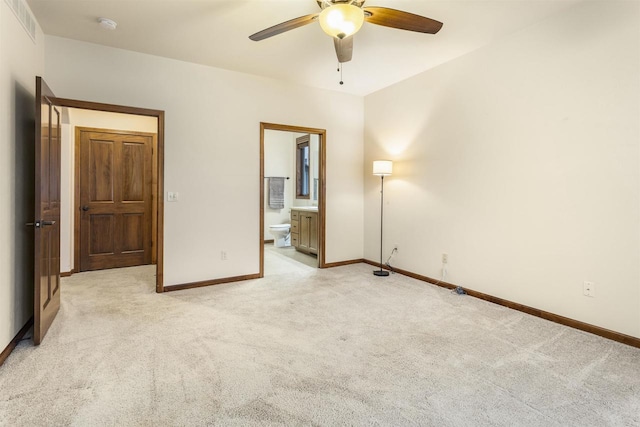 unfurnished bedroom featuring connected bathroom, light carpet, and ceiling fan