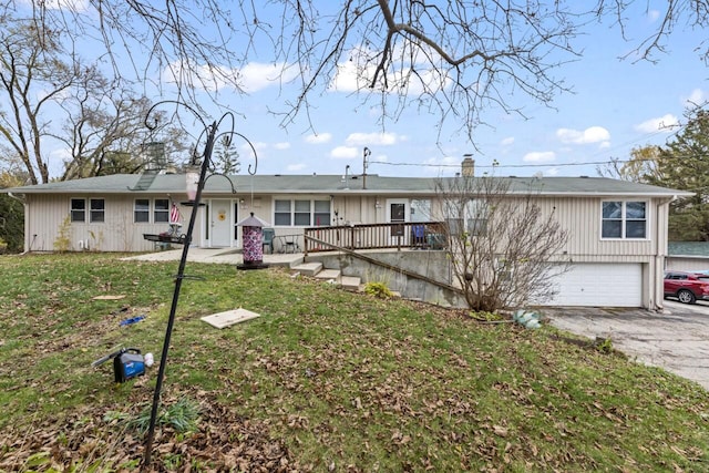 ranch-style house featuring a front lawn, a deck, and a garage