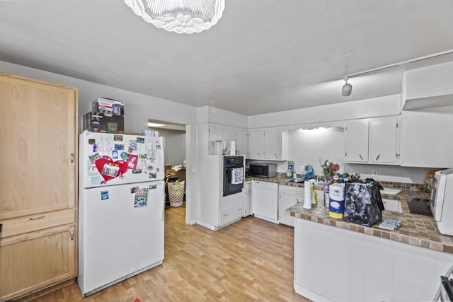 kitchen with white cabinets, white appliances, and light hardwood / wood-style floors