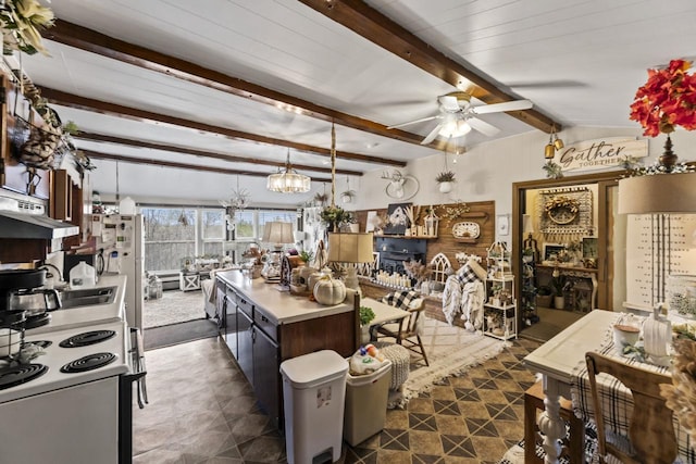 kitchen featuring a center island, ceiling fan with notable chandelier, hanging light fixtures, vaulted ceiling with beams, and extractor fan