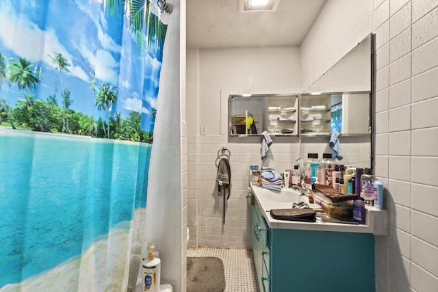 bathroom featuring vanity and tile walls