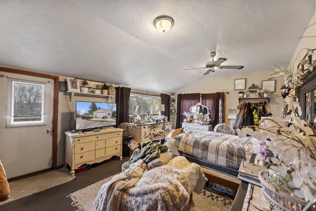 carpeted bedroom with a textured ceiling, ceiling fan, and vaulted ceiling