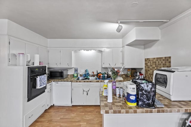 kitchen with light hardwood / wood-style flooring, white dishwasher, black oven, decorative backsplash, and white cabinets