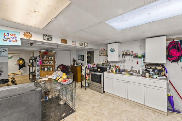 kitchen featuring white cabinetry, stainless steel range with electric cooktop, and sink