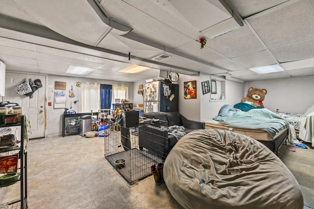 interior space featuring stainless steel fridge and a drop ceiling