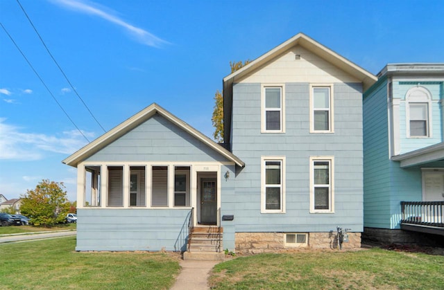 view of front of property featuring a sunroom and a front lawn