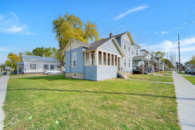 view of side of property with a sunroom and a yard