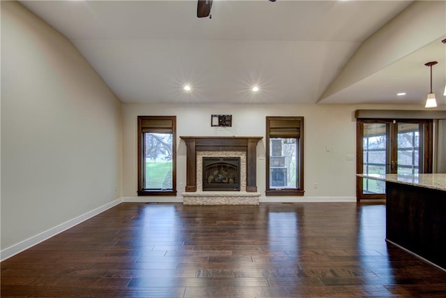 unfurnished living room featuring a wealth of natural light, french doors, dark hardwood / wood-style floors, and vaulted ceiling