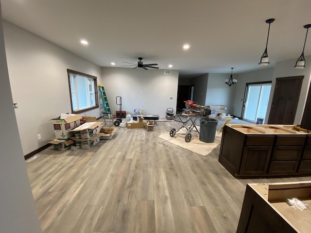 misc room with light hardwood / wood-style floors and ceiling fan with notable chandelier